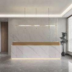 an empty lobby with a marble counter and plant in the corner on the right side