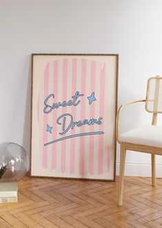 a pink and white striped poster sitting on top of a hard wood floor next to a chair