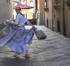 a woman is walking down the street with an umbrella in her hand and some shopping bags