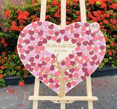 a wooden easel with a heart shaped tree cut out of it and hearts on the back