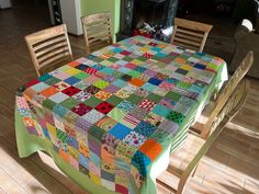 the table is covered with a multicolored patchwork quilt on it's center