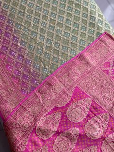 A Handmade Mehndi Green & Fuchsia Pink shaded Pure Khaddi Georgette Bandhani/ Bandhej Saree woven in pure Meenakari Zari- an invitation for a true self-indulgence. The fall and pico are done for this saree. It comes along with a Fuchsia Pink Bandhani Blouse piece that also has a zari border.   Our Policy on Returns, refunds and exchanges: We don't accept requests for returns and exchanges on the below observations: Non-defects: *Small knots or bumps in the silk threads.  *Uneven threads because Pink Sharara With Zari Weaving Traditional Drape, Festive Pink Sharara With Zari Weaving, Traditional Drape Pink Sharara With Zari Weaving, Pink Jamawar Sharara For Festivals, Diwali Pink Jamawar Sharara, Pink Jamawar Sharara For Diwali, Pink Sharara With Zari Weaving For Eid, Pink Semi-stitched Sharara With Zari Weaving, Navratri Pink Self Design Dupatta