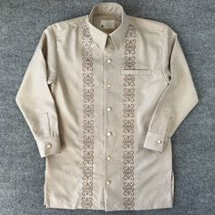 This Simenzz Designs long sleeve shirt is a must-have for any fashion-forward man. The shirt features an embroidered accent and a button-up closure for a classic look. Available in sizes S-XXXL, this shirt is perfect for any occasion, from casual wear to fancy events. The light brown color and cashme material are sure to impress, and the shirt is made in the United States for quality you can trust. Add this Rasgaga shirt to your wardrobe today! Pants are sold separately. Purchase both shirt and pants for a discounted price.  Message us for deal! Casual Long Sleeve Embroidered Shirt, Beige Fitted Shirt With Casual Collar, Embroidered Long Sleeve Formal Tops, Embroidered Long Sleeve Tops For Formal Occasions, Single Breasted Long Sleeve Cotton Tops, Single Breasted Cotton Tops With Long Sleeves, Beige Long Sleeve Button Shirt, Single-breasted Cotton Tops With Long Sleeves, Single-breasted Long Sleeve Cotton Tops