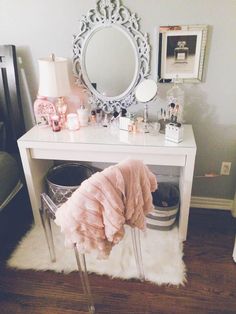 a white vanity with a mirror, stool and other items on top of the table