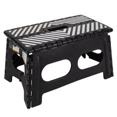 a black and white step stool with stripes on the bottom, one foot resting on it's side