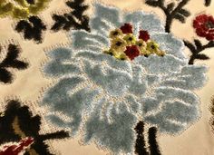 a close up of an embroidered cloth with flowers on it