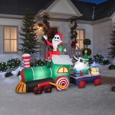 an inflatable christmas train with santa clause on top and other holiday decorations around it