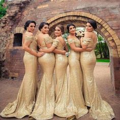 the bridesmaids are wearing gold dresses and posing for a photo in front of an old brick building