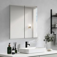 a white sink sitting under a bathroom mirror