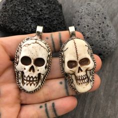 Unique and powerful double sided pendant, made with a skull made out of carved bone, and unique alloy metal designs around it and on its back. The back of the pendant has an embossed flower. The Pendant comes with a black leather cord, but you may choose to wear it with any chains that you already have as the bail is 1cm- 0.40 inch in diameter. The skull pendant itself is 5cm- 2 inch long 2.5cm- 1 inch wide A unique addition to your jewelry collection ⚡️GET 20% OFF by joining Akashi's VIP List ⚡ Unique Carved Bone Jewelry, Unique Bone-colored Carved Jewelry, White Gothic Skull Jewelry, Halloween Skull Jewelry In Bone Color, Halloween Skull Shaped Bone Jewelry, White Bohemian Skull Jewelry, White Skull Jewelry For Day Of The Dead, White Skull Print Jewelry, Big Pendant Necklace