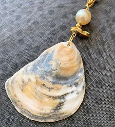 One of a kind handmade Oyster & Pearl Shell Necklace. An assemblage of pretty beads top this patterned oyster shell pendant: 12mm Pearl bead, faceted gold hematite bead and a chunky gold quartz nugget are all strung together on an 18K gold plated chunky paper clip style chain. The genuine oyster seashell has two unique sides: a beautiful natural pattern in grey, gold and white with a matte ribbed texture. The glossy reverse side is hand gilded with metallic gold paint and sparkling natural pearl Metallic Gold Paint, Oyster Pearl, Nautical Gifts, Pretty Beads, Seashell Necklace, Handmade Headbands, Hematite Beads, Shell Necklace, Natural Pearl