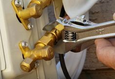 a person is holding a pair of pliers in front of a white and gold door