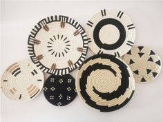 several woven baskets are arranged on a white tablecloth with black and brown designs in the center