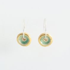 A gorgeous pair of small ceramic hoop earrings in rich sea-coloured green glass and gold detailing. Stylish and delicately designed, these sterling silver hoops are light and comfortable to wear. Made from ceramic, glass, real gold detailing and sterling silver hoops. Timeless and sophisticated handcrafted women's jewellery. Each piece has been carefully hand-shaped and painted, adding an elegant and contemporary feel. The kiln-fired glass gives the piece a high quality and gemstone-like appearance. The luxurious smoothness of the pooled glass gives a soothing sensory experience - similar to that of a comforting touchstone you would keep in your pocket. It's hard to describe, but we just can't stop feeling the surface with our fingers! As each individual piece is handmade, each one is comp Green Small Hoop Sterling Silver Jewelry, Green Sterling Silver Small Hoop Jewelry, Green Sterling Silver Small Hoop Earrings, Green Small Hoop Earrings For Everyday, Stop Feeling, Sea Colour, Sensory Experience, Sterling Silver Hoops, It's Hard