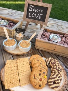 an assortment of cookies and crackers on a table with a sign that says s'more love