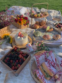 an outdoor picnic with food and snacks on the table in front of it, along with flowers