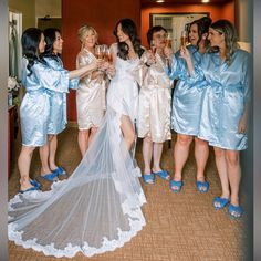 a group of women standing next to each other wearing blue shoes and holding champagne glasses