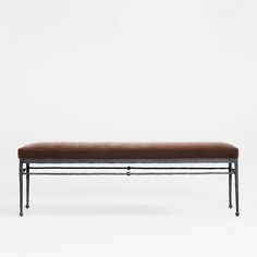 a bench with metal legs and a brown cushion