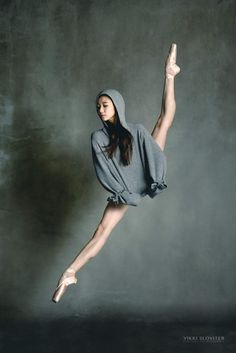 a woman in grey shirt and skirt doing a dance pose