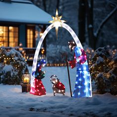 lighted nativity scene in front of house at night