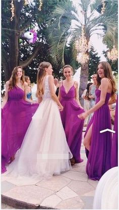 two girls in purple dresses are holding hands with another girl wearing a white and pink dress