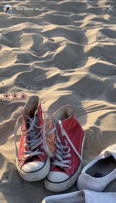 two pairs of shoes sitting in the sand