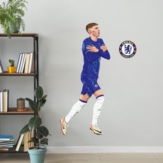 a soccer player is jumping in the air to catch a ball with his hands and feet