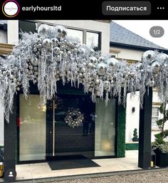 the entrance to an apartment decorated with silver and white christmas balls, snowflakes and wreaths