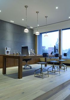 an empty office with two desks and chairs in front of large windows overlooking the city