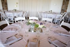 the table is set with silverware and white linens for an elegant wedding reception