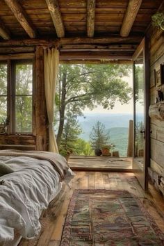 a bedroom with a large window overlooking the valley and mountains is shown in this image