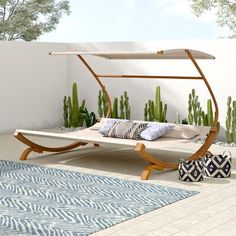 an outdoor daybed with a canopy and pillows on it in the middle of a patio