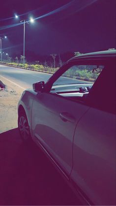 a car parked on the side of a road at night