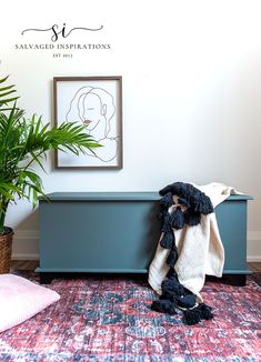 a blanket is sitting on top of a blue bench next to a potted plant