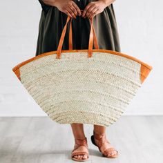 This oversized tote bag will take you everywhere you need to go! Woven with reeds and finished with attractive and durable leather accents and straps, the Rosemerra Handwoven Basket Tote has enough room for all of your essentials for a day at the beach, pool, park, and beyond. Exact size and shape will vary. Handcrafted by artisans with OTICART in Kenya. Vacation Straw Bag With Leather Trim, Travel Straw Bag With Leather Trim, Rectangular Straw Bag With Leather Trim For Vacation, Leather Beach Bag With Braided Handles, Natural Leather Beach Bag For Shopping, Natural Leather Trim Shoulder Bag For Vacation, Natural Shoulder Bag With Leather Trim For Vacation, Natural Straw Bag With Leather Trim For Beach, Natural Straw Bag With Leather Trim And Double Handle