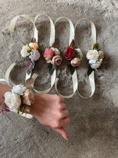 two brides hands with flowers and ribbons on the floor next to their wedding rings