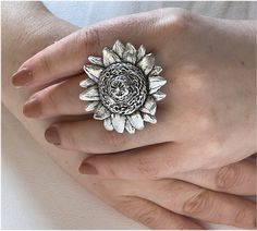 Dress your fingers with the splendor of nature with our Handmade Sunflower Big Ring. Meticulously crafted, this piece of boho-chic jewelry is a testament to individual style and artisanal quality. The ring features a radiant sunflower design, symbolizing happiness and warmth, making it an eye-catching centerpiece for any ensemble. Forged from high-quality silver plating, this chunky ring is not only gorgeous but durable and made to last. Adjustability is at the heart of this design, ensuring a c Bohemian Flower Ring As A Gift, Bohemian Sunflower Jewelry For Gift, Bohemian Sunflower Jewelry As Gift, Bohemian Flower Ring For Wedding, Bohemian Sunflower Design Jewelry As Gift, Handmade Nature-inspired Flower Ring, Handmade Adjustable Spiritual Flower Ring, Bohemian Flower Ring For Jewelry Making, Bohemian Flower Shaped Rings For Gifts