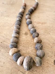 a necklace made out of stones on a wooden table