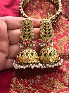 Beautiful traditional Jhumkas with Polki, pink and green jade stones. These are high quality beautiful Jhumkas,perfect for any festivities and occasion.  The earring are on the heavier side weigh around 59 grams.   There are huge cluster of faux pearls hanging from each jhmukis. Traditional Heavy Jhumkas For Festive Occasions, Traditional Tilla Chandbali Jhumkas, Festive Traditional Cutdana Jhumkas, Traditional Chandbali Tilla Jhumkas, Traditional Gold Jhumkas With Zari Work, Festive Traditional Jhumkas With Cutdana, Traditional Green Jhumkas For Wedding, Traditional Jhumkas With Latkans For Festive Occasions, Traditional Chandbali Jhumkas With Latkans