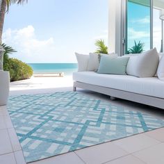 a white couch sitting on top of a blue rug