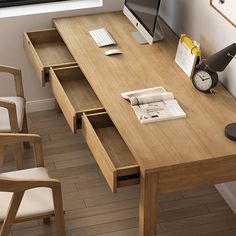 a wooden desk with two chairs and a computer monitor on it, next to a window