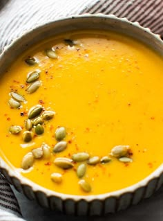 a bowl of soup with pumpkin seeds in it