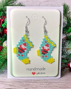 a pair of handmade beaded earrings in the shape of a pacman on a christmas tree