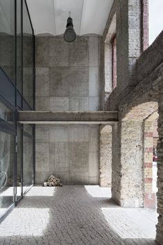 an empty room with brick floors and large glass doors on the side of the building