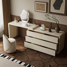 a white desk sitting in the middle of a living room next to a large window