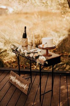 a wooden table topped with a cake and flowers