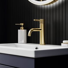 a bathroom sink with gold faucet and soap dispenser