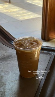 a cup of iced coffee sitting on top of a table