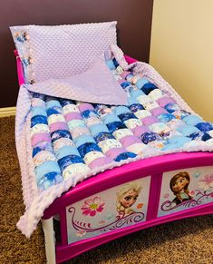 a bed with princess bedspread and pillows on it