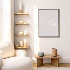 a living room with a white couch and coffee table in front of a framed poster